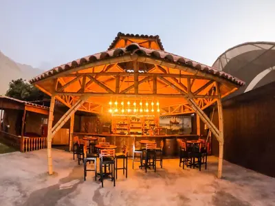 a wooden pavilion with tables and chairs on a patio at Taypu bungalow in Lunahuaná