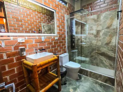 a brick bathroom with a sink and a shower at Taypu bungalow in Lunahuaná