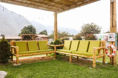two yellow and green chairs sitting under a pergola at Taypu bungalow in Lunahuaná