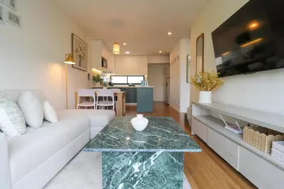 a living room with a white couch and a glass table at Pendragon by Wynwood House in Lima