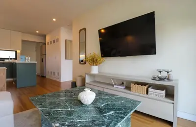 a living room with a marble table and a flat screen tv at Pendragon by Wynwood House in Lima