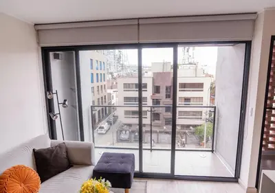 a living room with a couch and a large window at Maravilla en barranco BR1 in Lima