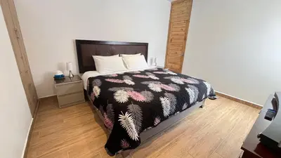 a bedroom with a bed with a black and white comforter at RANCH HAUS OXAPAMPA - PeT FRIENDLY in Oxapampa