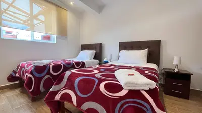 a bedroom with two beds and a window at RANCH HAUS OXAPAMPA - PeT FRIENDLY in Oxapampa