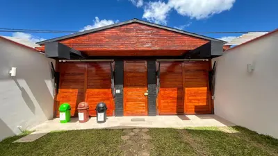 a house with wooden doors and two trash cans at RANCH HAUS OXAPAMPA - PeT FRIENDLY in Oxapampa