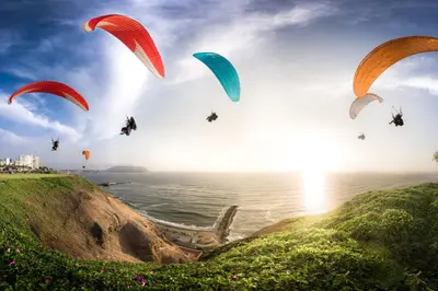 a group of people riding parachutes over the ocean at Modern loft in front of the boardwalk and the sea in Lima