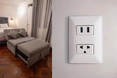 a room with a bed and a chair and a lightswitch at Modern loft in front of the boardwalk and the sea in Lima
