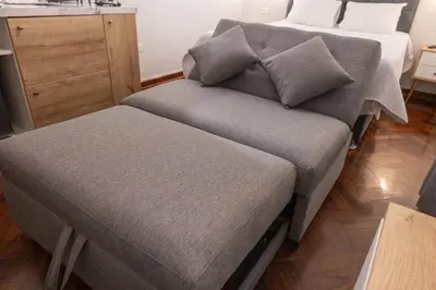 a bed and a couch in a room at Modern loft in front of the boardwalk and the sea in Lima