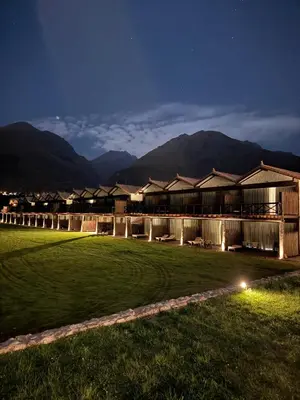 a row of houses at night with mountains in the background at RUSTICA HOTELES CUSCO Urubamba in Pachar