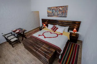a bedroom with a bed with a heart drawn on it at RUSTICA HOTELES CUSCO Urubamba in Pachar