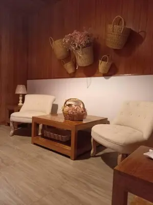a living room with two chairs and a coffee table and a table at Posada de la Sirga Oxapampa De 8 a 10 personas in Oxapampa