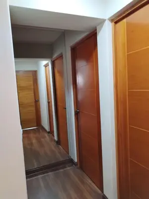 a hallway with wooden doors and a mirror at El Libertador Apartment Miraflores in Lima