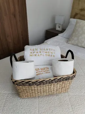 a basket with towels and pillows on a bed at El Libertador Apartment Miraflores in Lima
