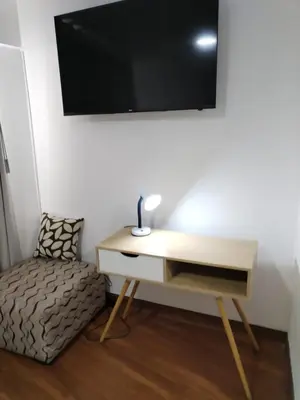 a desk with a tv on a wall next to a chair at El Libertador Apartment Miraflores in Lima