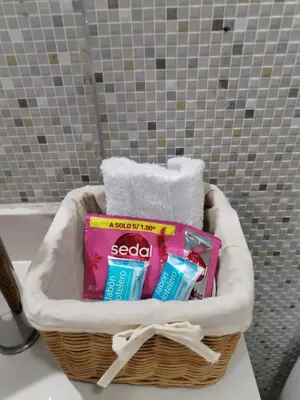 a basket filled with toiletries and towels in a bathroom at El Libertador Apartment Miraflores in Lima