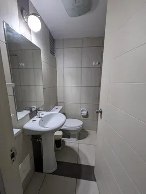 a bathroom with a sink and a toilet and a mirror at Guernica Apartments in Lima