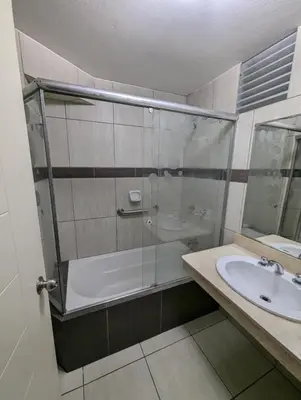 a bathroom with a glass shower and a sink at Guernica Apartments in Lima