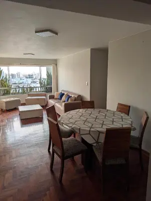 a living room with a table and chairs and a couch at Guernica Apartments in Lima