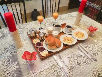 a table with a tray of food and glasses of orange juice at Hostal Ocean Pacifico in Punta Negra