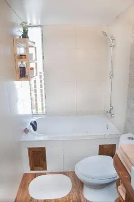a white bathroom with a toilet and a bath tub at Departamento jacuzzi Miraflores in Lima