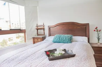a bedroom with a bed with a tray of flowers on it at Departamento jacuzzi Miraflores in Lima