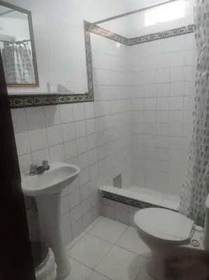 a white bathroom with a sink and a toilet at Cómoda habitación independiente Miraflores in Lima