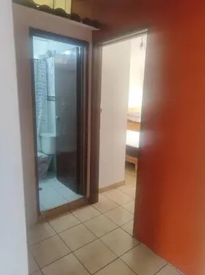 a bathroom with a toilet and a glass door at Cómoda habitación independiente Miraflores in Lima