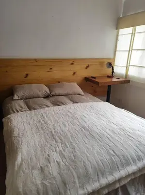 a bedroom with a white bed with a wooden headboard at Cómoda habitación independiente Miraflores in Lima