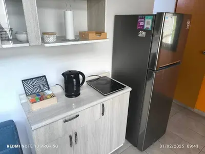 a kitchen with a refrigerator and a counter with a kettle on it at home Blessed III in Lima