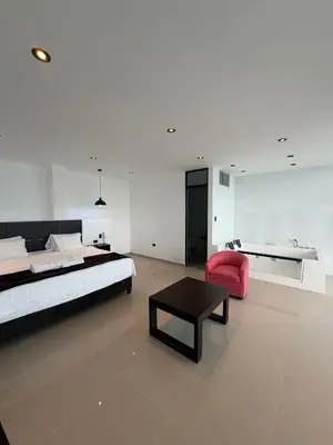 a bedroom with a large bed and a pink chair at Vista a Mar in Huaral