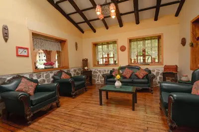a living room with leather couches and a table at Hotel Samanapaq in Ollantaytambo