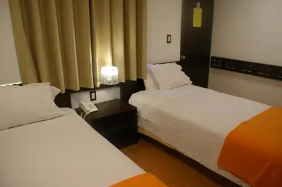 a hotel room with two beds and a phone at Hotel Samanapaq in Ollantaytambo