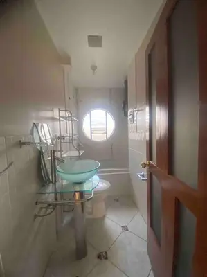 a bathroom with a sink and a toilet with a window at Casa Elizabeth in Huancayo