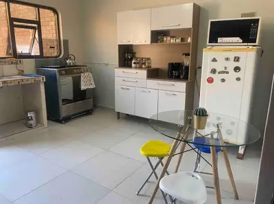 a kitchen with a glass table and a refrigerator at Casa Elizabeth in Huancayo