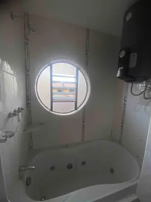 a bathroom with a bath tub with a window at Casa Elizabeth in Huancayo