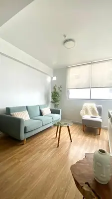 a living room with a blue couch and a table at Vista Brasil Dúplex in Lima