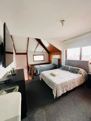 a bedroom with two beds and a desk and a television at MONTERRICO POLO APARTS #4 - Dpto Completo Familiar 2 camas a una cuadra Embajada USA in Lima