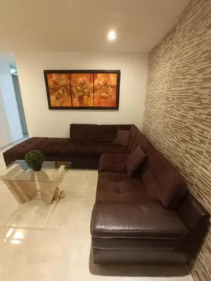 a living room with a brown couch and a table at Apartam in Lima