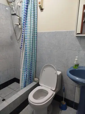 a bathroom with a toilet and a blue shower curtain at Habitación H3, TV y WIFI cerca a Barranco in Lima