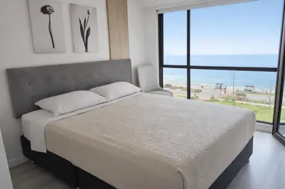 a bedroom with a large bed and a large window at Suite Romántica Vista al Mar Cerca al Aeropuerto y Miraflores in Lima