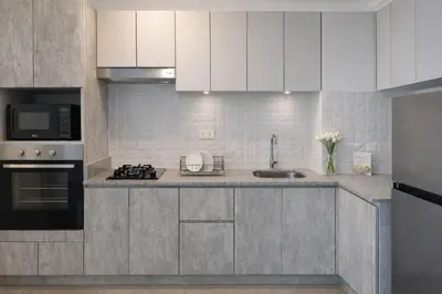 a kitchen with white cabinets and a sink at Suite Romántica Vista al Mar Cerca al Aeropuerto y Miraflores in Lima