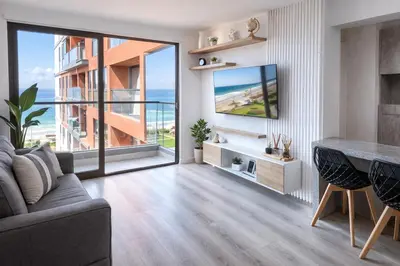a living room with a couch and a large window at Suite Romántica Vista al Mar Cerca al Aeropuerto y Miraflores in Lima