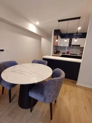 a room with a table and chairs and a kitchen at Luxurious Apartment Besso in Lima