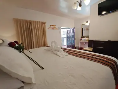 a bedroom with a white bed with flowers on it at Afma Cusco in Cusco