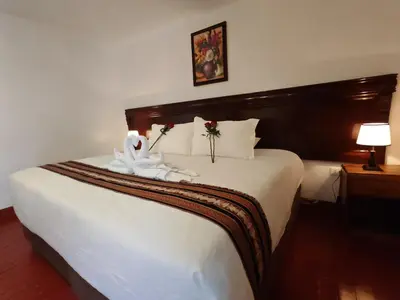 a bedroom with a large white bed with flowers on it at Afma Cusco in Cusco