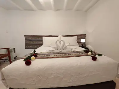 a white bed with a wedding bouquet on it at Afma Cusco in Cusco