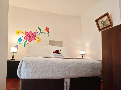 a bedroom with a bed with a flower mural on the wall at Afma Cusco in Cusco