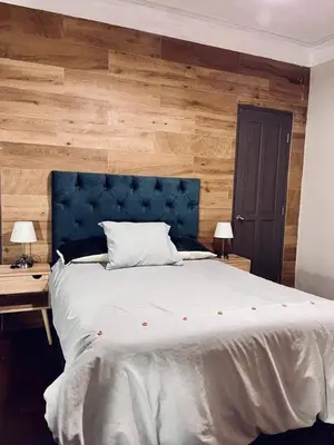 a bedroom with a large bed with a blue headboard at Suite 201 in Lima
