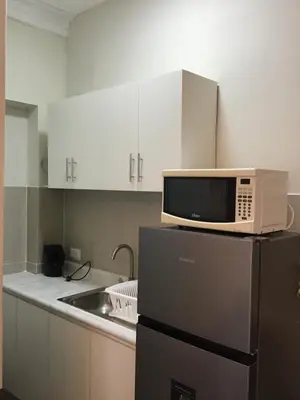 a microwave on top of a refrigerator in a kitchen at Suite 201 in Lima