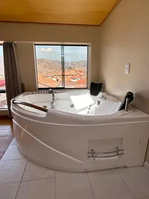 a white bath tub in a room with a window at Duplex panorámico in Cusco